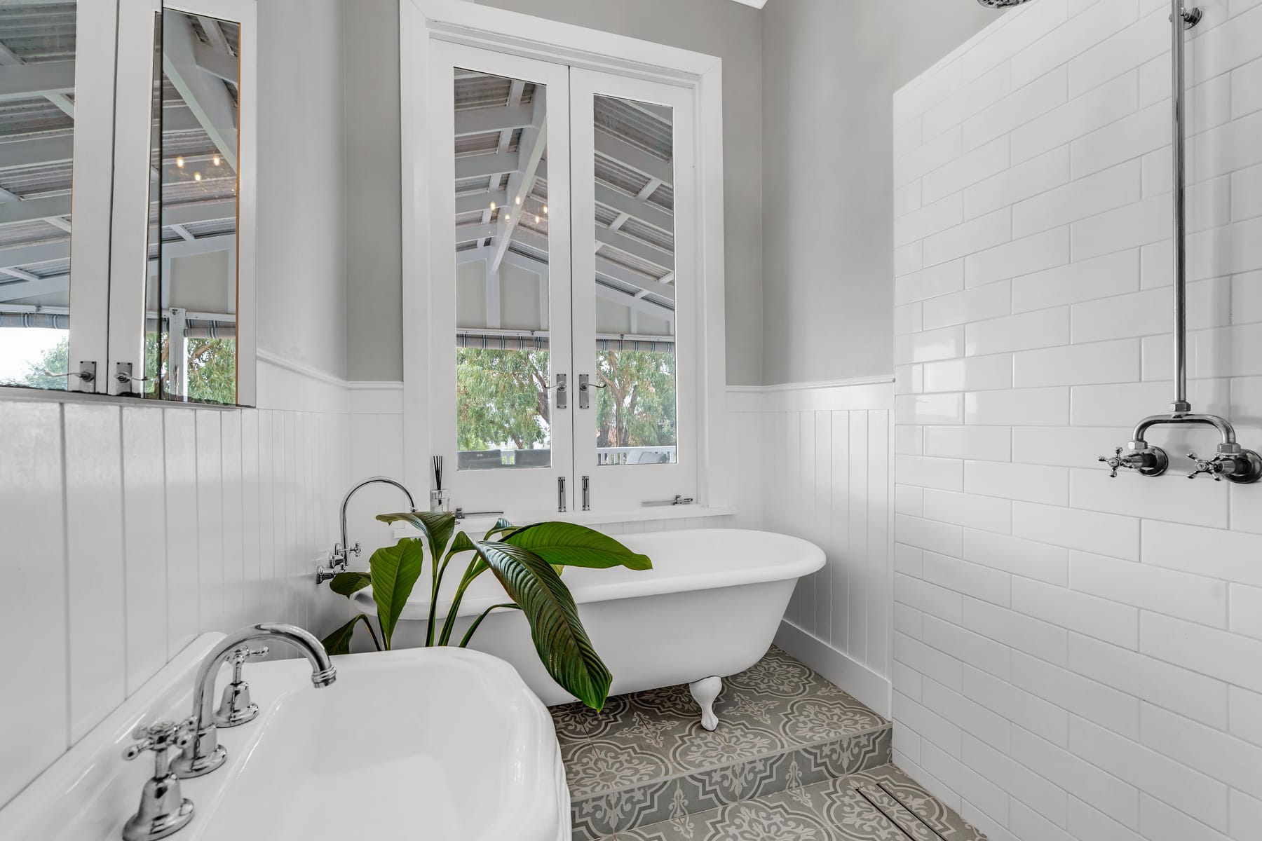 White bathroom with a freestanding bath and patterned floor